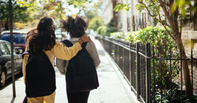 School's out - two kids walk outside with backpacks
