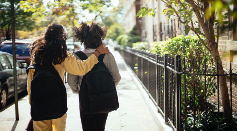 School's out - two kids walk outside with backpacks